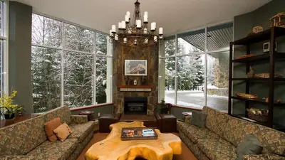 a living room with couches and a table and a fireplace at Woodrun Lodge 514 | Ski-In Ski-Out Condo w/ Pool, Hot Tub, Free Parking, Wifi & Laundry in Whistler