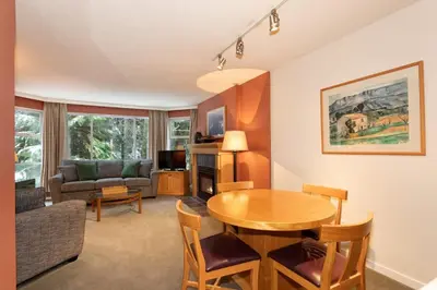 a living room with a table and a couch at Woodrun Lodge 416 | Family Ski-In Ski-Out Condo, Hot Tub, Heated Pool, Parking & Laundry in Whistler