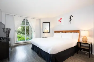 a bedroom with a large bed and a window at Woodrun Lodge 107 | New Listing! Ski-in, Ski-Out, Heated Pool, Hot Tub & Parking in Whistler