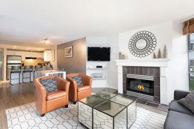 a living room with couches and a fireplace at Woodrun Lodge 107 | New Listing! Ski-in, Ski-Out, Heated Pool, Hot Tub & Parking in Whistler