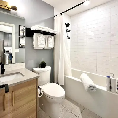 a bathroom with a toilet and a tub and a sink at Brand New 2BR Condo with Outdoor Swimming Pool and Hot Tub in Canmore