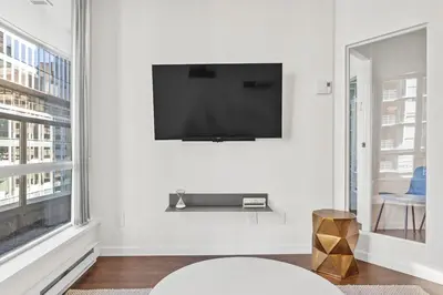 a living room with a flat screen tv on a wall at Downtown Luxury 1BR Coal Harbour in Vancouver