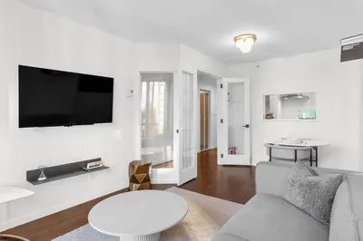 a living room with a couch and a tv on a wall at Downtown Luxury 1BR Coal Harbour in Vancouver