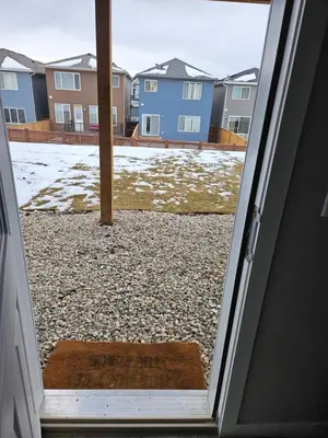 an open door to a yard with snow on the ground at Like cozy place in Calgary