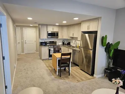 a kitchen with a table and stainless steel appliances at Like cozy place in Calgary