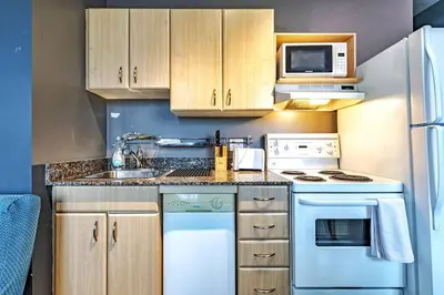 a kitchen with white appliances and wooden cabinets at Industrial-Style Cityscape 1 Bedroom Loft in Edmonton