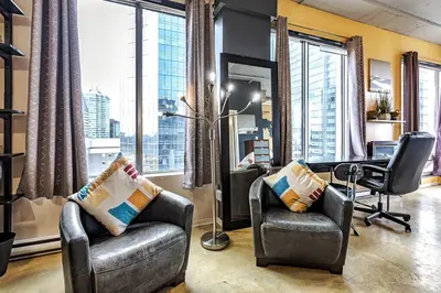 an office with two chairs and a desk and large windows at Industrial-Style Cityscape 1 Bedroom Loft in Edmonton