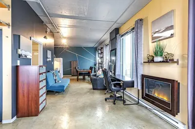 a living room with a fireplace and a desk and a couch at Industrial-Style Cityscape 1 Bedroom Loft in Edmonton