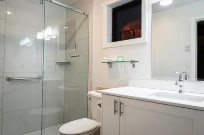 a bathroom with a shower and a toilet and a sink at Poplars Motel on the lake in Osoyoos
