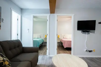 a living room with a couch and a bedroom at Poplars Motel on the lake in Osoyoos