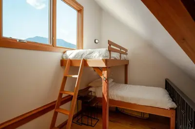 a bunk bed in a room with a window at The Ikon Lofted Studio with King Bed and Patio in Whistler