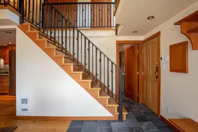a staircase in a home with wooden railings at The Ikon Lofted Studio with King Bed and Patio in Whistler