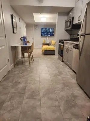 a kitchen with a table and a couch in a room at Deluxe 2 bedroom suite with*Netflix/Cable/Prime in Edmonton