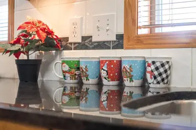 a row of christmas mugs sitting on a kitchen counter at Coral Springs Lakefront Retreat in Calgary