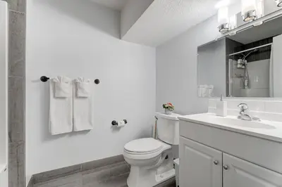 a white bathroom with a toilet and a sink at Coral Springs Lakefront Retreat in Calgary