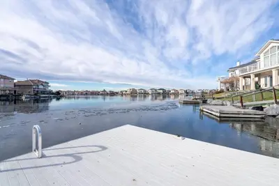 a view of a river with houses and a dock at Coral Springs Lakefront Retreat in Calgary