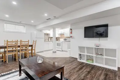 a living room with a table and a kitchen at Coral Springs Lakefront Retreat in Calgary