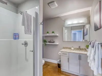 a bathroom with a sink and a toilet and a mirror at Cozy 2BR Condo with King Bed and City Views in Calgary