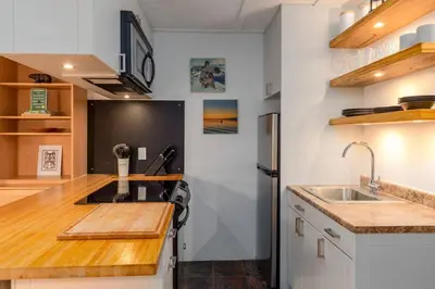 a kitchen with a sink and a black refrigerator at Casa Creekside - Walk to Gondola, Shops, lakes! in Whistler