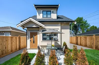 a backyard with a table and an umbrella at Three bedrooms new laneway house near public transit & FIFA training site in Vancouver