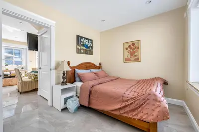 a bedroom with a bed with a pink bedspread at Three bedrooms new laneway house near public transit & FIFA training site in Vancouver