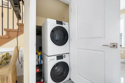 a laundry room with a washer and dryer next to a staircase at Three bedrooms new laneway house near public transit & FIFA training site in Vancouver