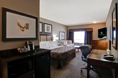 a hotel room with a bed and a desk at Canalta Lac La Biche in Lac La Biche