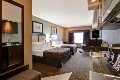 a hotel room with two beds and a bathroom at Canalta Lac La Biche in Lac La Biche