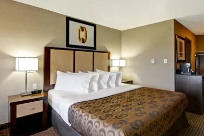 a hotel room with a large bed and two lamps at Canalta Lac La Biche in Lac La Biche