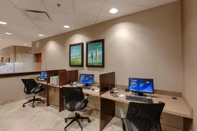 an office cubicle with four computer desks and chairs at Canalta Lac La Biche in Lac La Biche