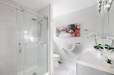 a white bathroom with a shower and a toilet at NorthVAN nature living home in North Vancouver