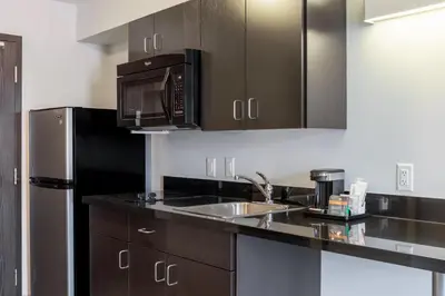a kitchen with a sink and a microwave at Motel 6 Airdrie in Airdrie