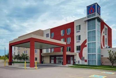a red and white building with a clock tower at Motel 6 Airdrie in Airdrie