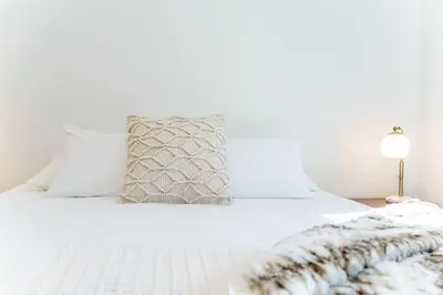 a white bed with a blanket and a lamp at Mountainview Escape by Revelstoke Vacations in Revelstoke