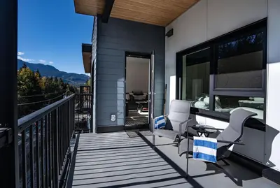 a balcony of a house with two chairs and a table at Mountainview Escape by Revelstoke Vacations in Revelstoke