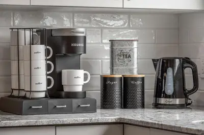 a kitchen counter with cups and appliances on it at Extra Large House with AC, Banff Access, Sleep 12, BBQ, 4 Bedrooms & 2 Sleeper Sofa Beds in Airdrie