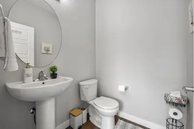 a bathroom with a sink and a toilet and a mirror at Extra Large House with AC, Banff Access, Sleep 12, BBQ, 4 Bedrooms & 2 Sleeper Sofa Beds in Airdrie