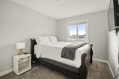 a bedroom with a bed and a window at Extra Large House with AC, Banff Access, Sleep 12, BBQ, 4 Bedrooms & 2 Sleeper Sofa Beds in Airdrie
