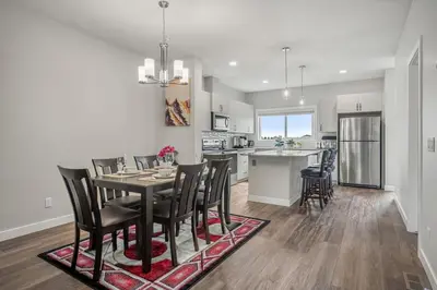 a kitchen and dining room with a table and chairs at Extra Large House with AC, Banff Access, Sleep 12, BBQ, 4 Bedrooms & 2 Sleeper Sofa Beds in Airdrie