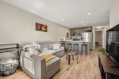 a living room with a couch and a kitchen at Private Town Home with Free Banff Access, Netflix, King Bed, Fully Equipped Kitchen, Sleeps 4 in Calgary