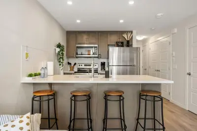 a kitchen with a large island with bar stools at Private Town Home with Free Banff Access, Netflix, King Bed, Fully Equipped Kitchen, Sleeps 4 in Calgary