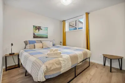 a bedroom with a bed with two towels on it at Private Town Home with Free Banff Access, Netflix, King Bed, Fully Equipped Kitchen, Sleeps 4 in Calgary
