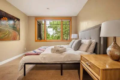 a bedroom with a large bed and a window at Escape to the Rockies but near Calgary Includes Free Parking and Banff Entry in Calgary