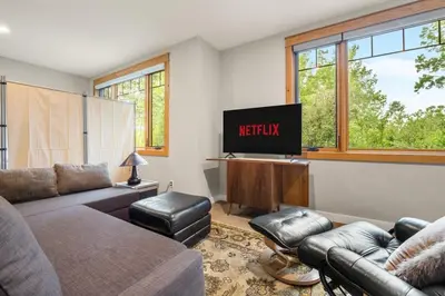 a living room with a couch and a flat screen tv at Escape to the Rockies but near Calgary Includes Free Parking and Banff Entry in Calgary