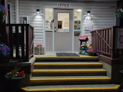 a front door of a store with stairs and flowers at Elks Motel in Keremeos