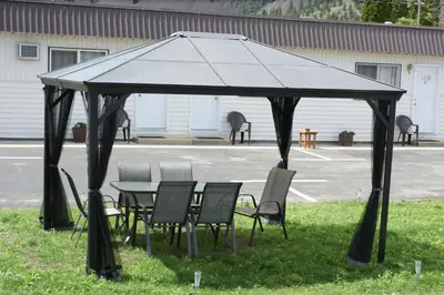 a gazebo with chairs and a table in the grass at Elks Motel in Keremeos