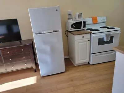 a kitchen with a white refrigerator and a microwave at Elks Motel in Keremeos