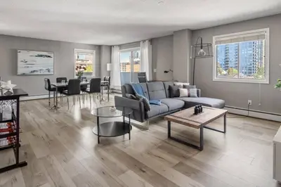 a living room with a couch and a table at Downtown Apartment with Underground Parking, Netflix, Fully Equipped Kitchen, Walk to 17th Ave, Sleeps 4, Perfect for Foodies and Tourists in Calgary