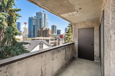 a door on a wall with a view of the city at Downtown Apartment with Underground Parking, Netflix, Fully Equipped Kitchen, Walk to 17th Ave, Sleeps 4, Perfect for Foodies and Tourists in Calgary