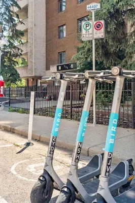 two scooters are parked on the side of a street at Downtown Apartment with Underground Parking, Netflix, Fully Equipped Kitchen, Walk to 17th Ave, Sleeps 4, Perfect for Foodies and Tourists in Calgary